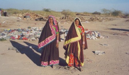 Women standing in front of piles of clothes
